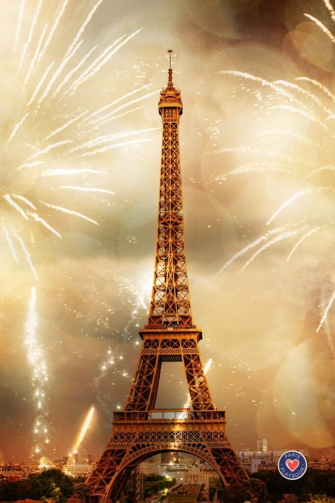 Eiffel Tower surrounded by spectacular golden fireworks display against amber sky with explosive bursts of light creating dramatic celebration atmosphere